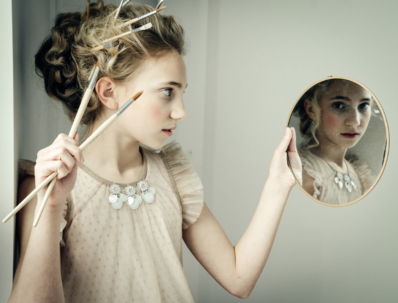 Denver Children's Photography, girl with paint brushes in her hair, looking into a mirror
