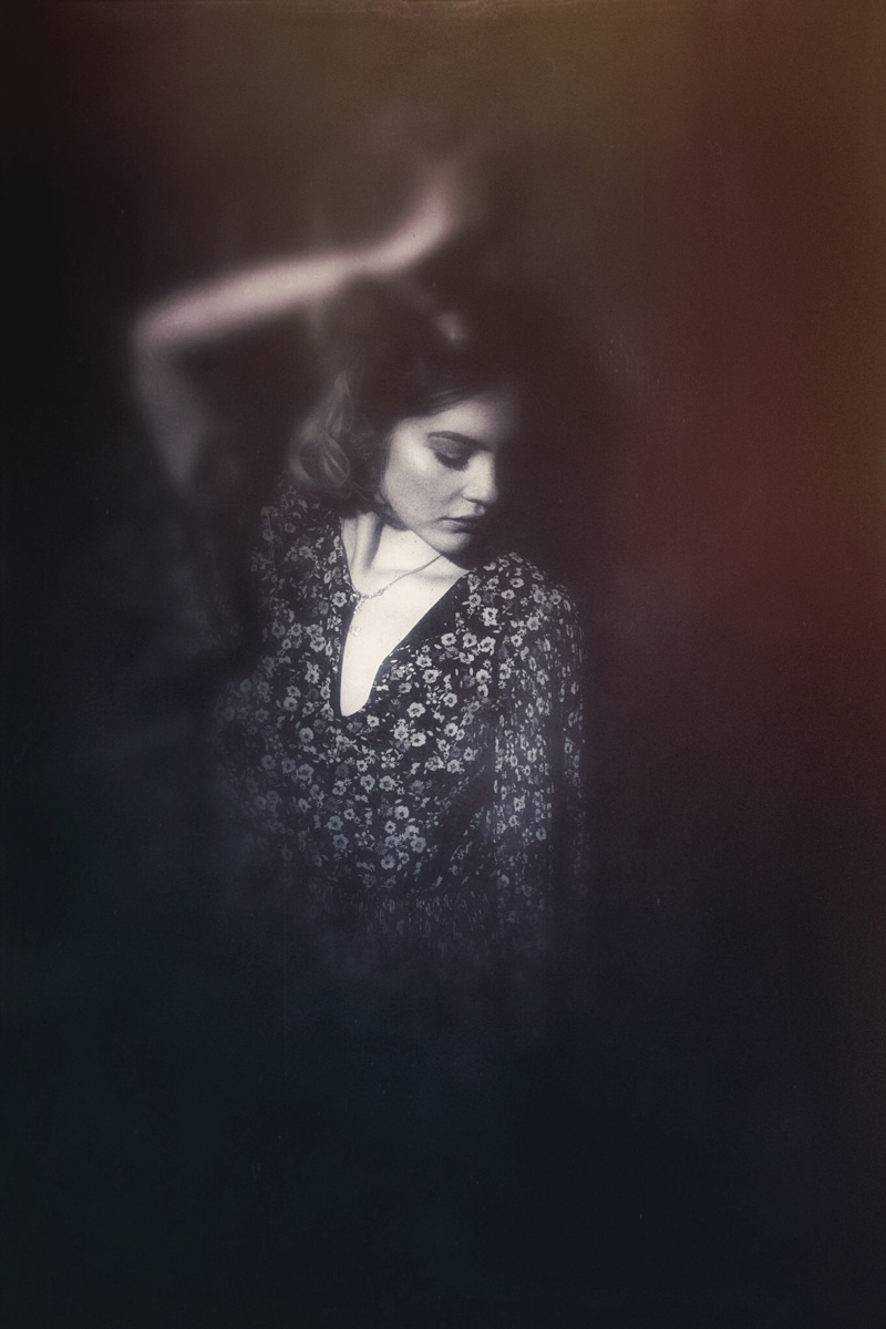 Denver Senior Photography, artistically edited girl leaning against a dark background